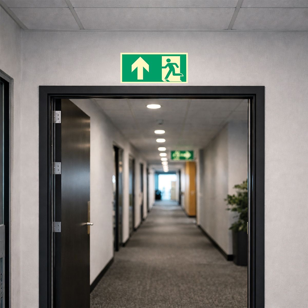 Nødutgangskilt med pil opp for merking av rømningsvei